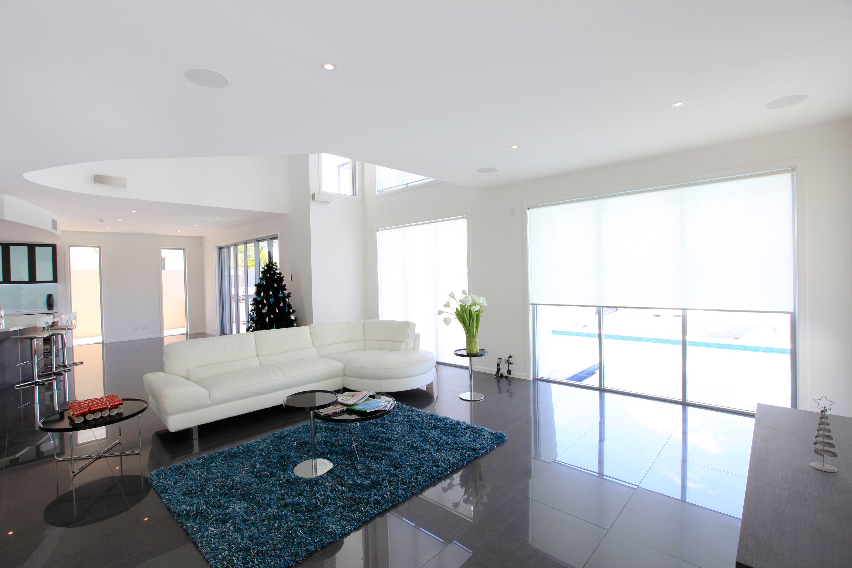 Large open living area with white roller blinds